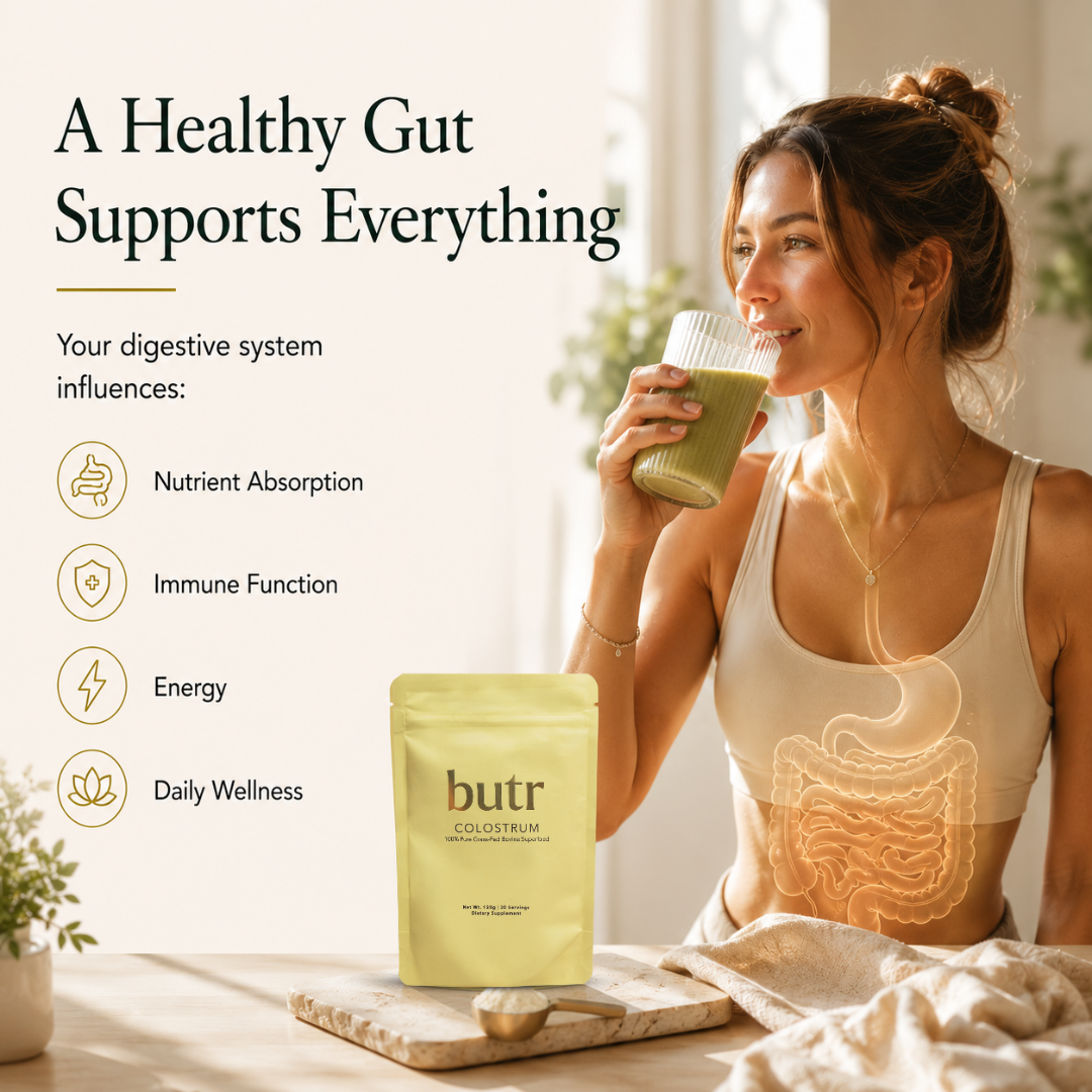 Woman drinking a green smoothie with 'butr' colostrum package, highlighting gut health benefits.