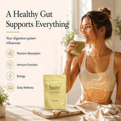 Woman drinking a green smoothie with 'butr' colostrum package, highlighting gut health benefits.